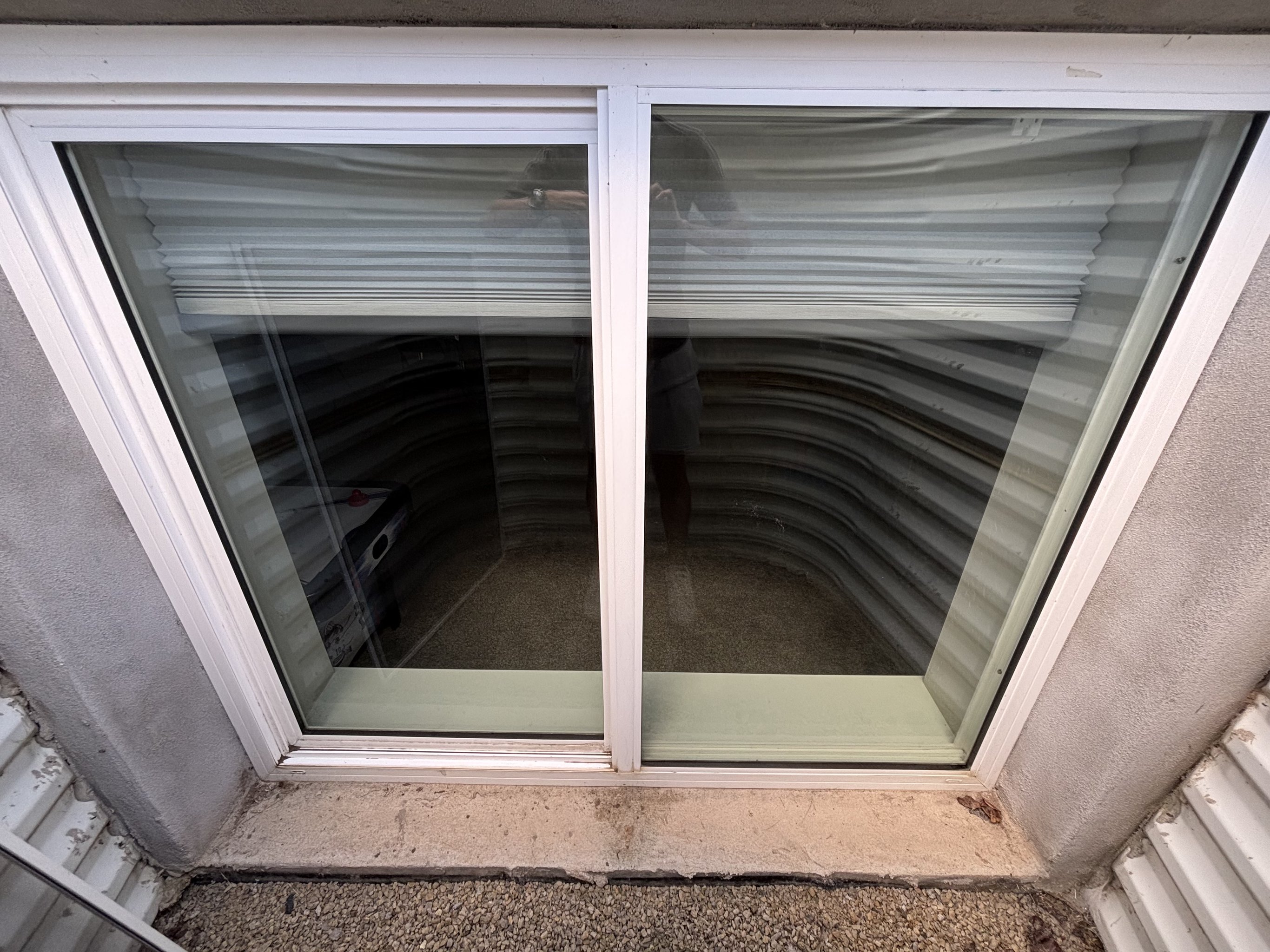 Blue squeegee cleaning a wet exterior window